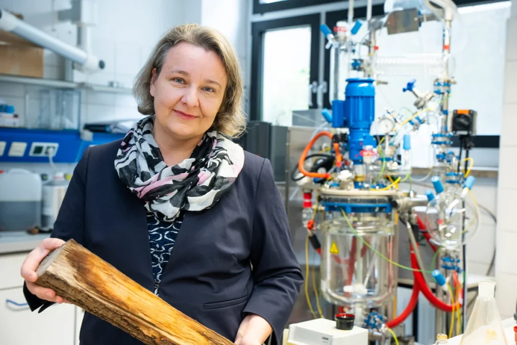 Photo of Katalin Barta holding a piece of wood